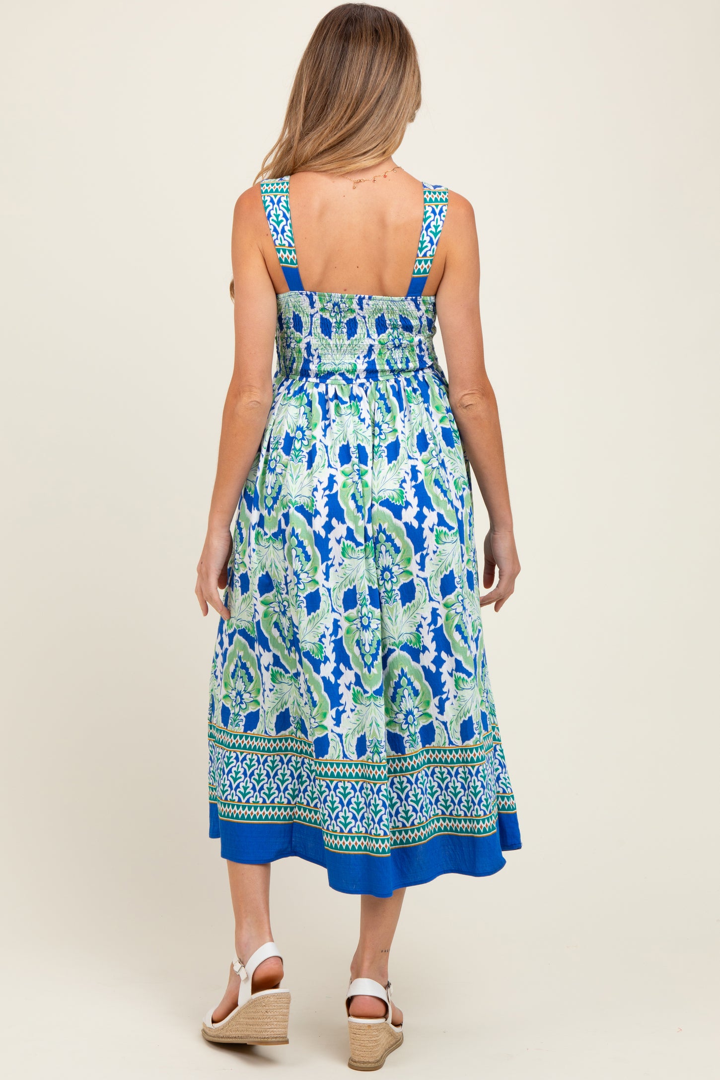 woman wearing a blue and green patterned maternity maxi dress with a smocked back and wide straps