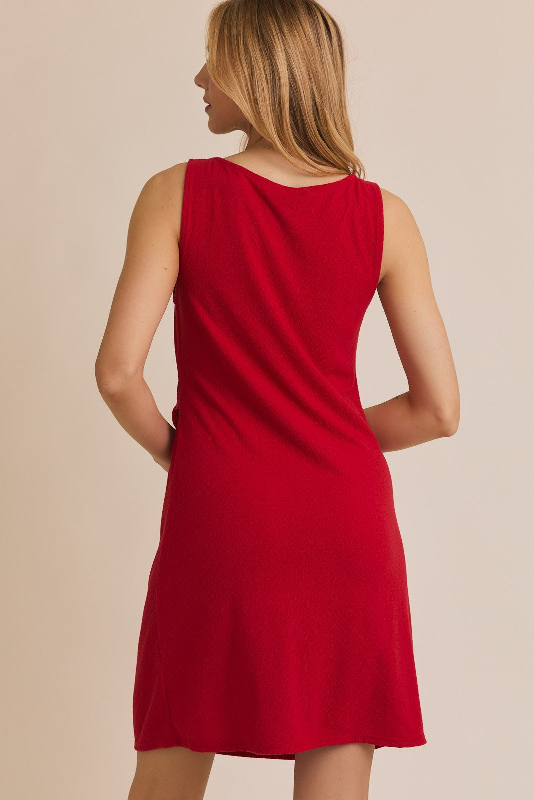 woman wearing a red sleeveless swing dress seen from the back
