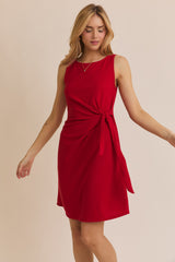 woman wearing a red sleeveless dress with a tied waist detail and a relaxed fit