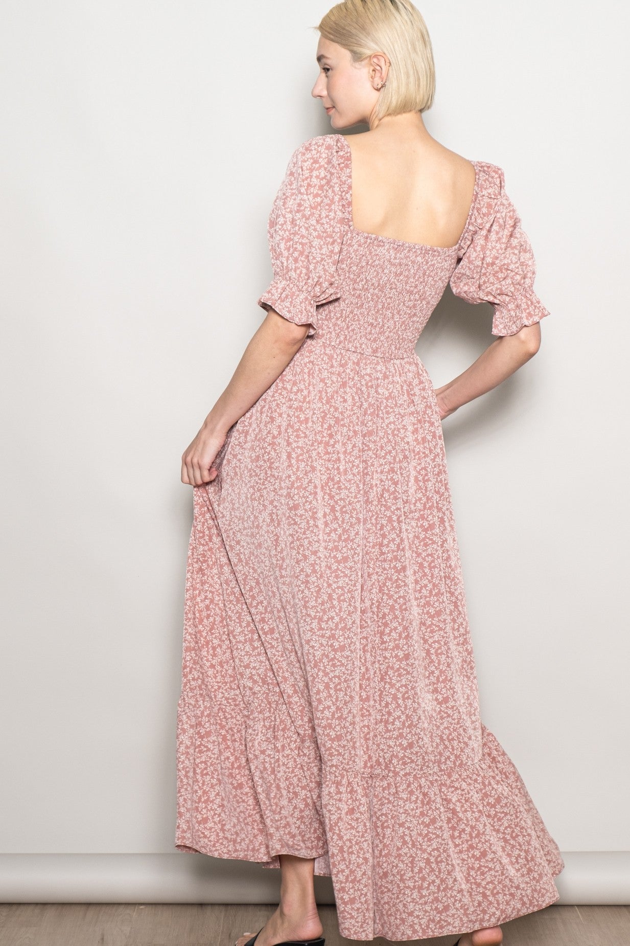 woman wearing a pink floral maxi dress with puff sleeves and a square neckline, shown from the back