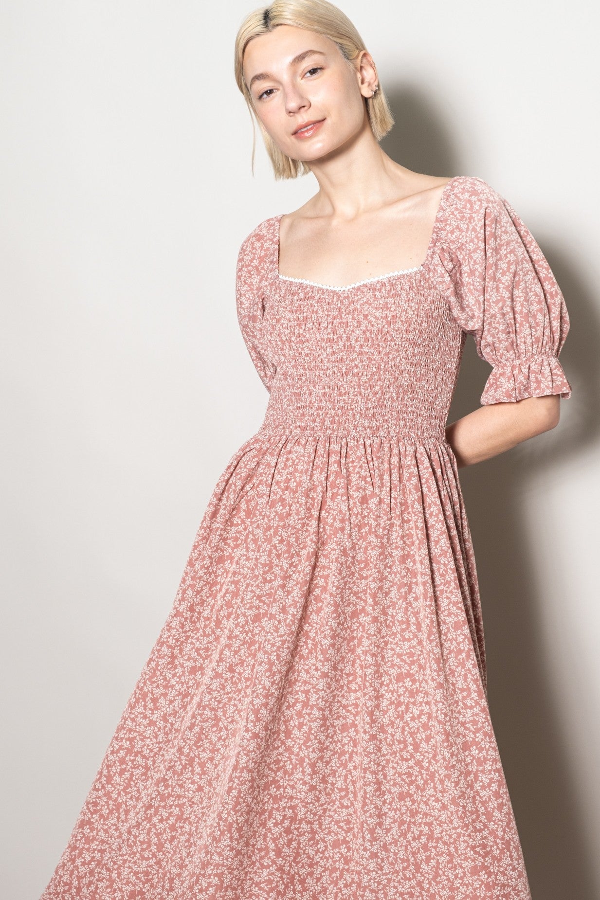 woman wearing a pink floral puff sleeve dress with a square neckline and fitted bodice