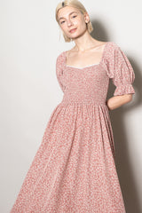 woman wearing a pink floral puff sleeve dress with a square neckline and fitted bodice
