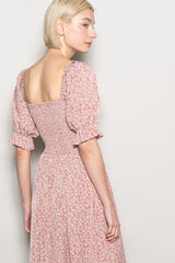 woman wearing a pink floral puff sleeve dress with a square back and fitted waist