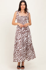 woman wearing a brown and white striped maxi dress with tie shoulder straps and a smocked bodice