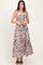woman wearing a brown and white striped maxi dress with tie shoulder straps and a smocked bodice