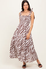 woman wearing a brown and white zebra print maxi dress with tie straps and a smocked bodice