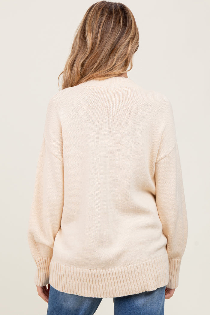 woman wearing a soft cream-colored oversized maternity sweater with ribbed hem and back view displayed
