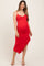 woman wearing a red maternity dress with ruffle hem and adjustable straps, showcasing her baby bump