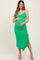 woman wearing a green maternity dress with a fitted style and ruffled hem, holding her baby bump