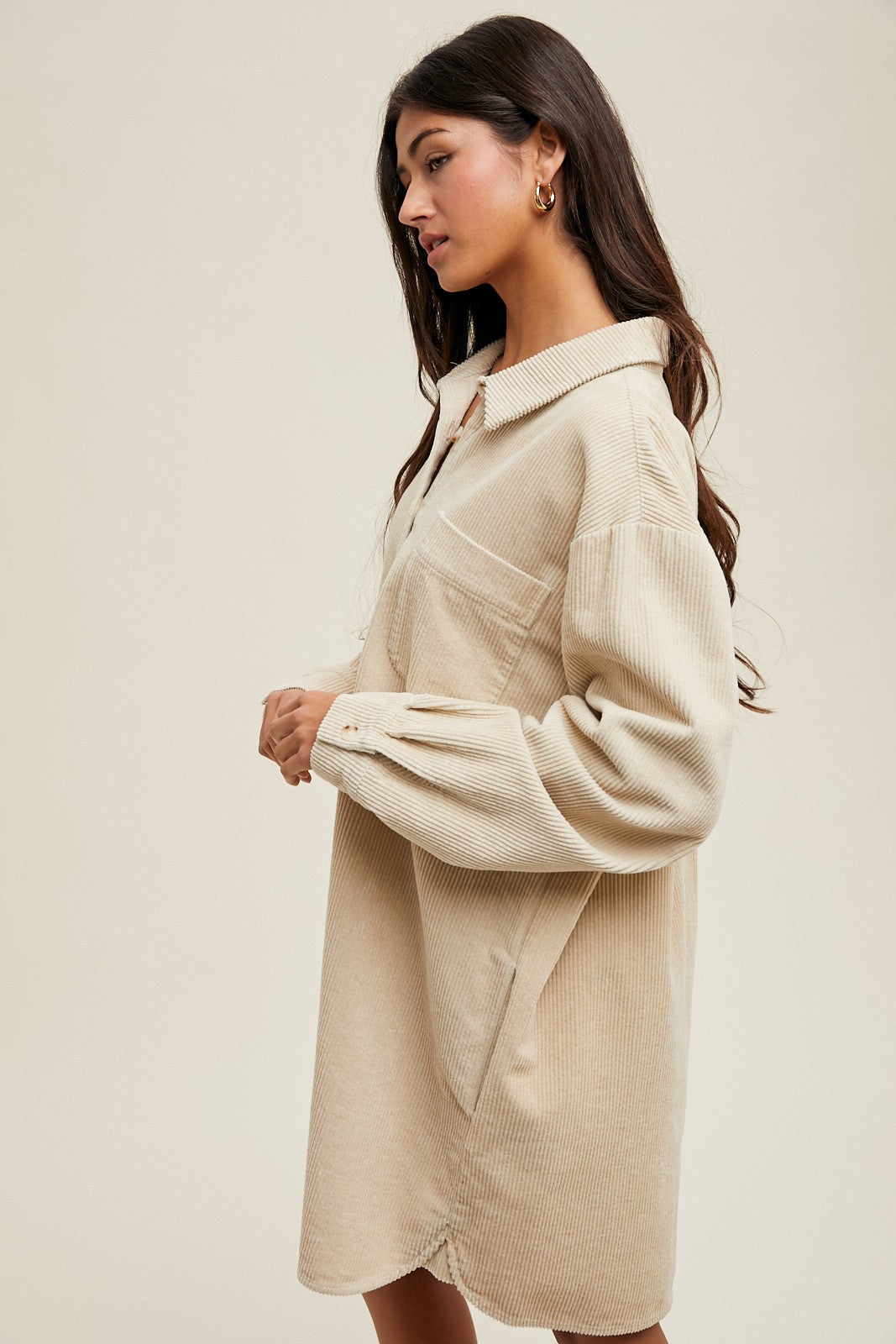 woman wearing a beige corduroy shirt dress with a collar and side pockets