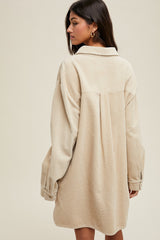woman wearing a beige oversized corduroy shirt dress with long sleeves and a collared neck
