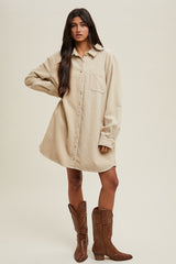 woman wearing a beige oversized button-up shirt dress paired with brown cowboy boots