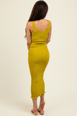woman wearing a mustard yellow fitted midi dress with a scoop neckline and ruffled hem, viewed from the back