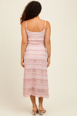 woman wearing a pink lace maternity dress with spaghetti straps and a midi length, showing the back view