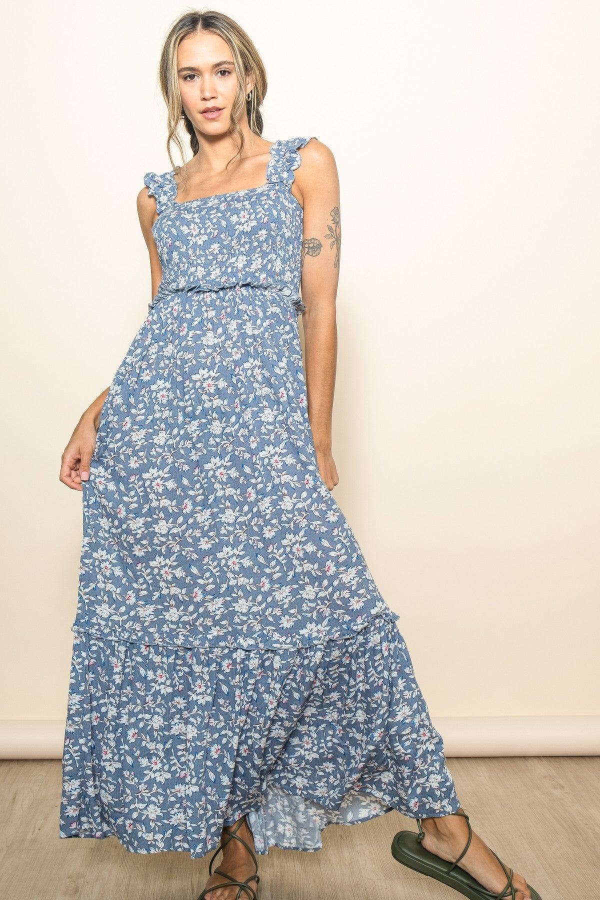 woman wearing a blue floral maxi dress with ruffle straps and a tiered skirt