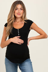 woman wearing a black ribbed maternity top with buttons and showing her baby bump