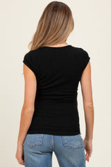 woman wearing a black ribbed maternity top with cap sleeves and a fitted silhouette