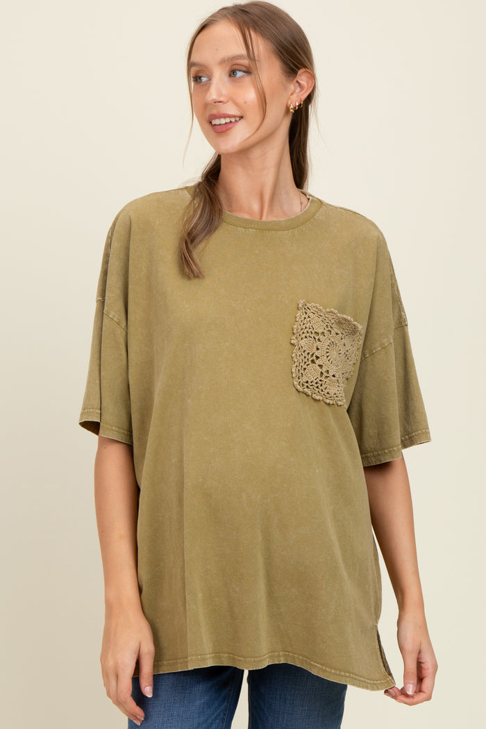 woman wearing an olive green oversized maternity t-shirt with a crochet pocket detail and a visible baby bump