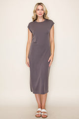 woman wearing a dark grey cap sleeve midi dress with side slits and standing on a plain background