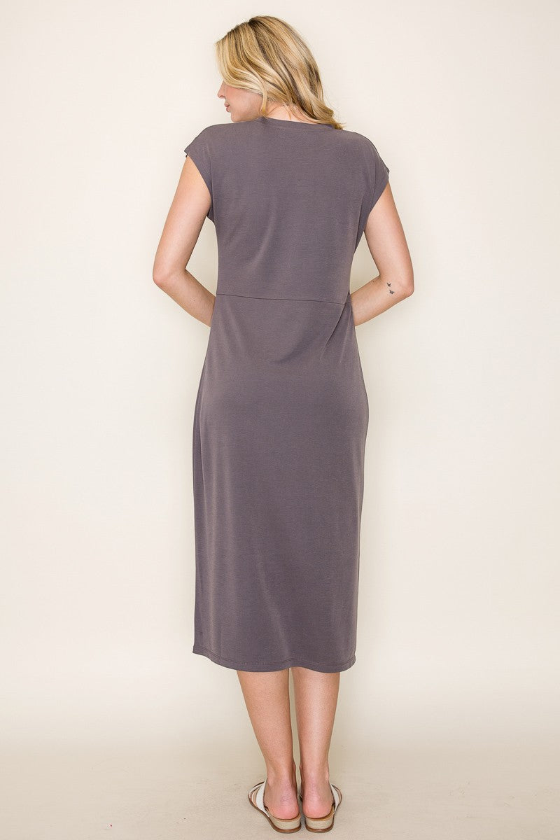 woman wearing a gray cap sleeve midi dress, showing the back view, standing with hands by her sides