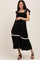 woman wearing a black maternity dress with ruffled sleeves and a tiered hem, holding her baby bump