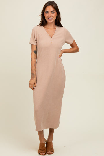 woman wearing a light beige short sleeve ribbed maxi dress with a v-neck and button details, standing and smiling