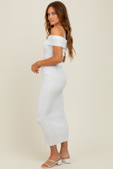 woman wearing a white off-the-shoulder ribbed maxi dress with a fitted silhouette and side slits