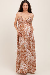 woman wearing a brown floral maternity maxi dress and holding her baby bump