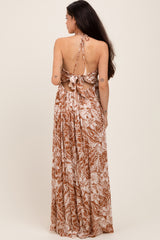 woman wearing a brown floral maternity maxi dress with an open back and tie details