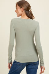 woman wearing a light green long sleeve maternity top viewed from the back with a relaxed fit and ribbed texture