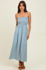 woman wearing a blue and white patterned maxi dress with spaghetti straps and a smocked bodice