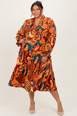 woman wearing an orange and blue floral print plus-size dress with long sleeves and a tiered skirt, smiling at the camera