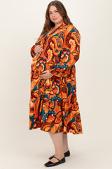 woman wearing a colorful floral maternity dress with long sleeves and a flowing skirt, showcasing her baby bump