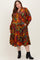 woman wearing a multicolored floral patterned maternity plus dress with tiered design and long sleeves