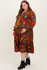 woman wearing a colorful floral maternity dress with a baby bump, paired with black ankle boots