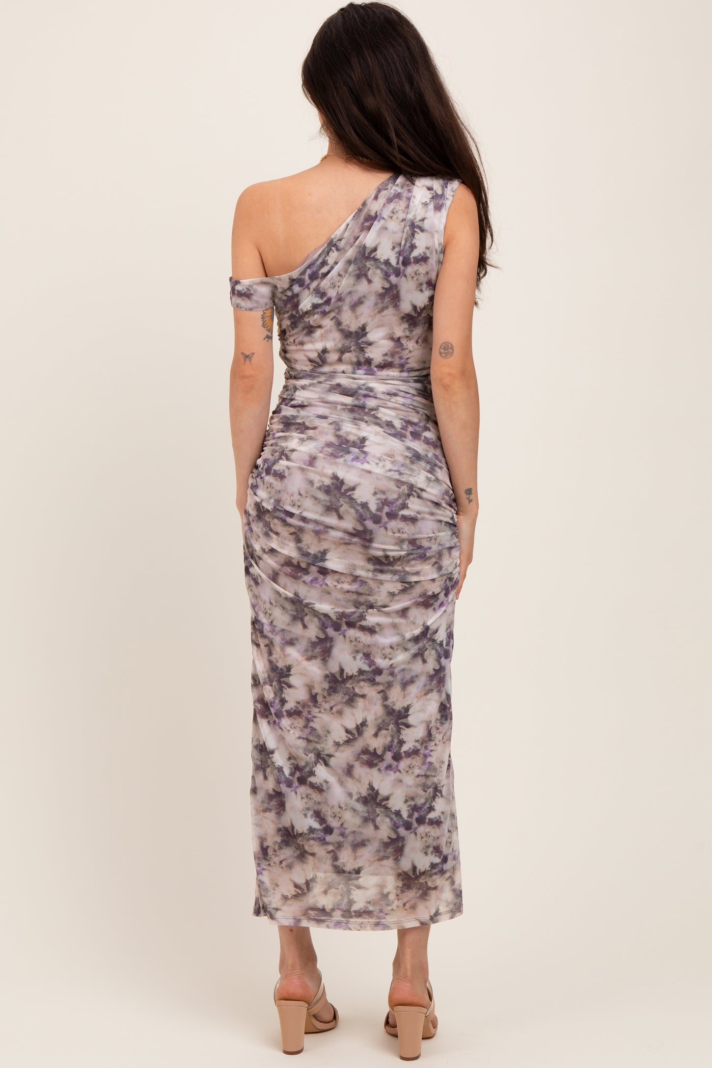 woman wearing a one-shoulder purple and gray tie-dye maternity dress with a fitted silhouette