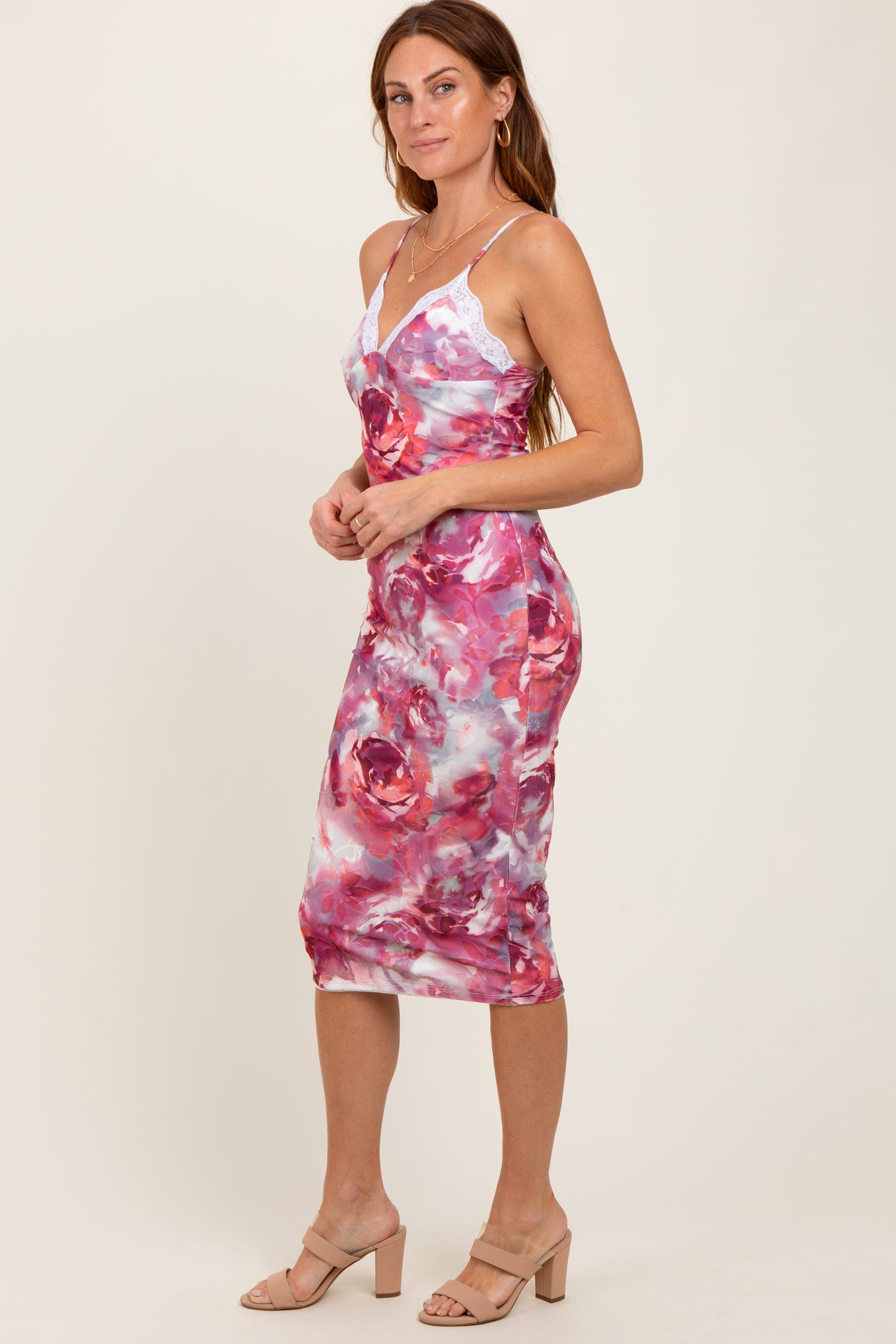woman wearing a pink and white floral midi dress with lace straps and a fitted silhouette
