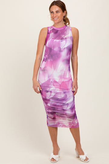 woman wearing a sleeveless purple floral bodycon dress with ruching detail and a fitted silhouette