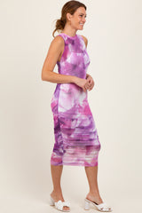 woman wearing a sleeveless purple watercolor print midi dress and white heeled sandals