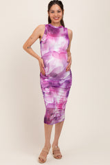 woman wearing a purple floral print maternity dress with ruching and a visible baby bump