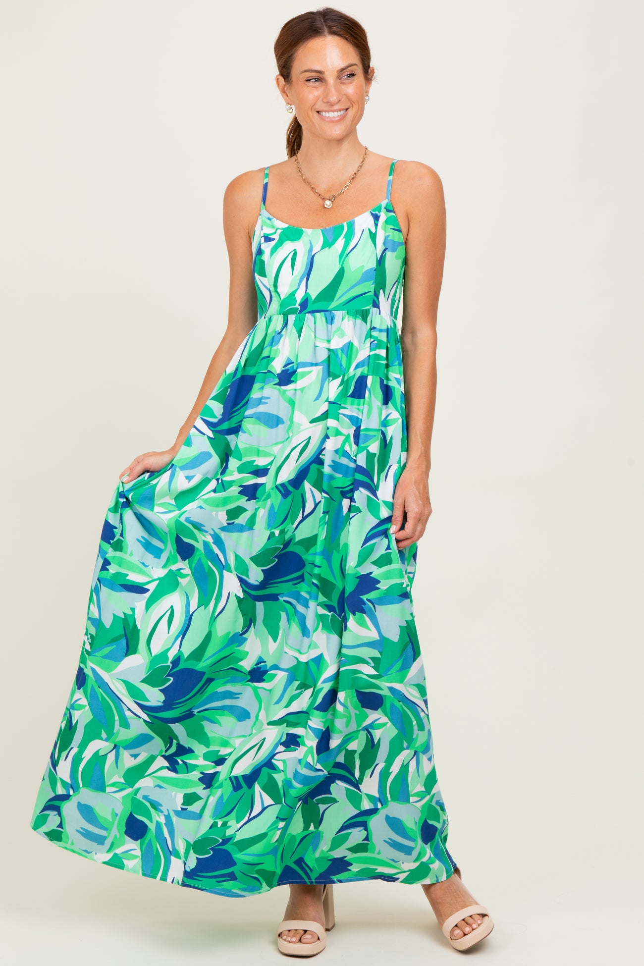 woman wearing a colorful floral maxi dress with adjustable straps and a flowy skirt