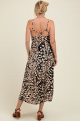 woman wearing a black and tan floral print maternity maxi dress with adjustable straps and a tied back detail