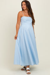 woman wearing a light blue spaghetti strap maternity maxi dress, styled with a flowy silhouette