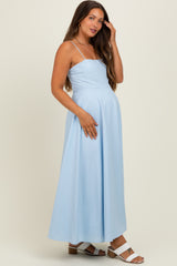 woman wearing a light blue maternity maxi dress with spaghetti straps and a baby bump visible