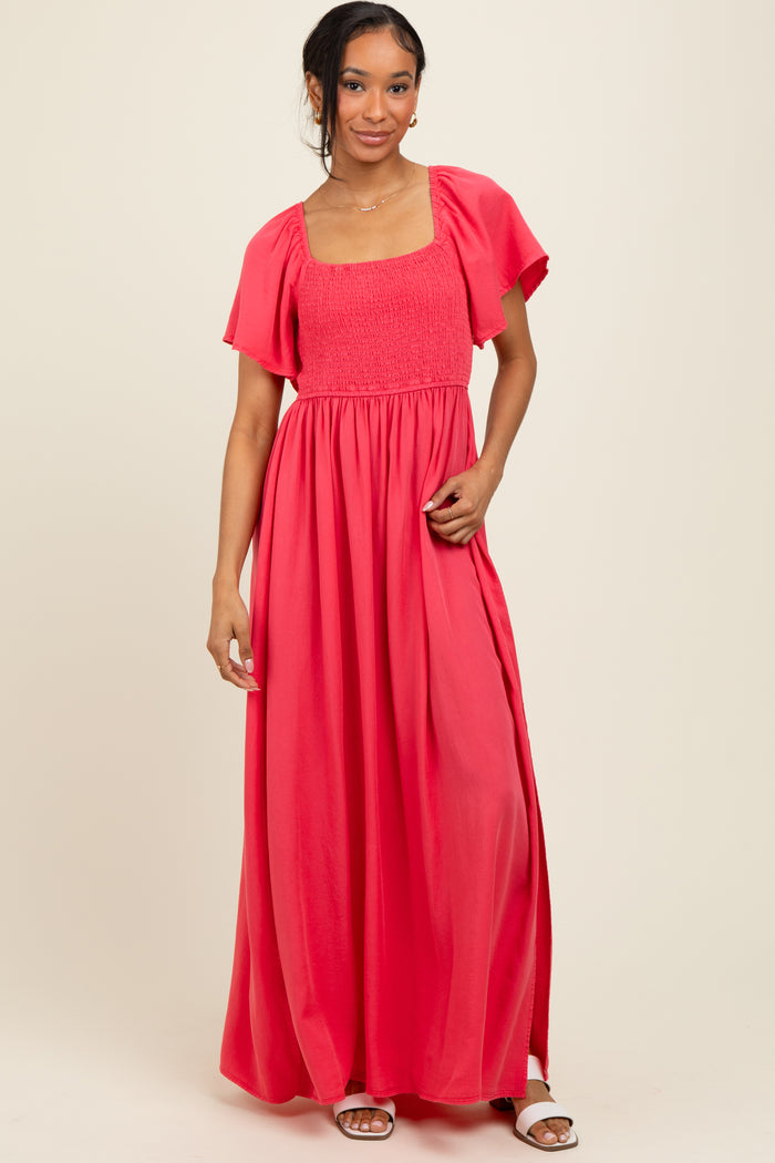 woman wearing a coral maxi dress with a square neckline, short sleeves, and a comfortable smocked bodice