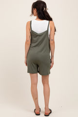 woman wearing a green maternity romper with a relaxed fit and adjustable straps, showing a casual style from the back