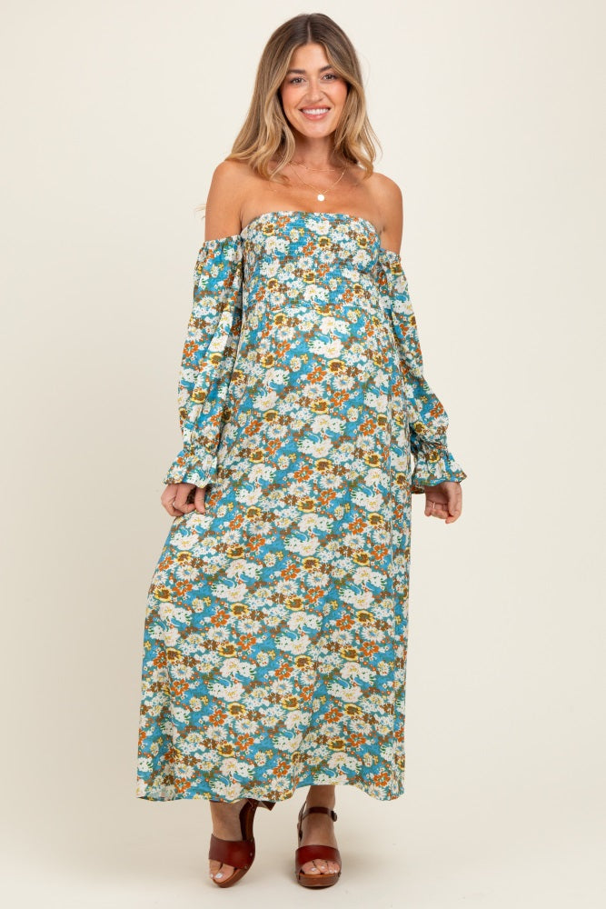 woman wearing a floral off-the-shoulder maternity maxi dress with long sleeves and a visible baby bump