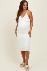 woman wearing a white knitted maternity dress with ruffle detail and a visible baby bump