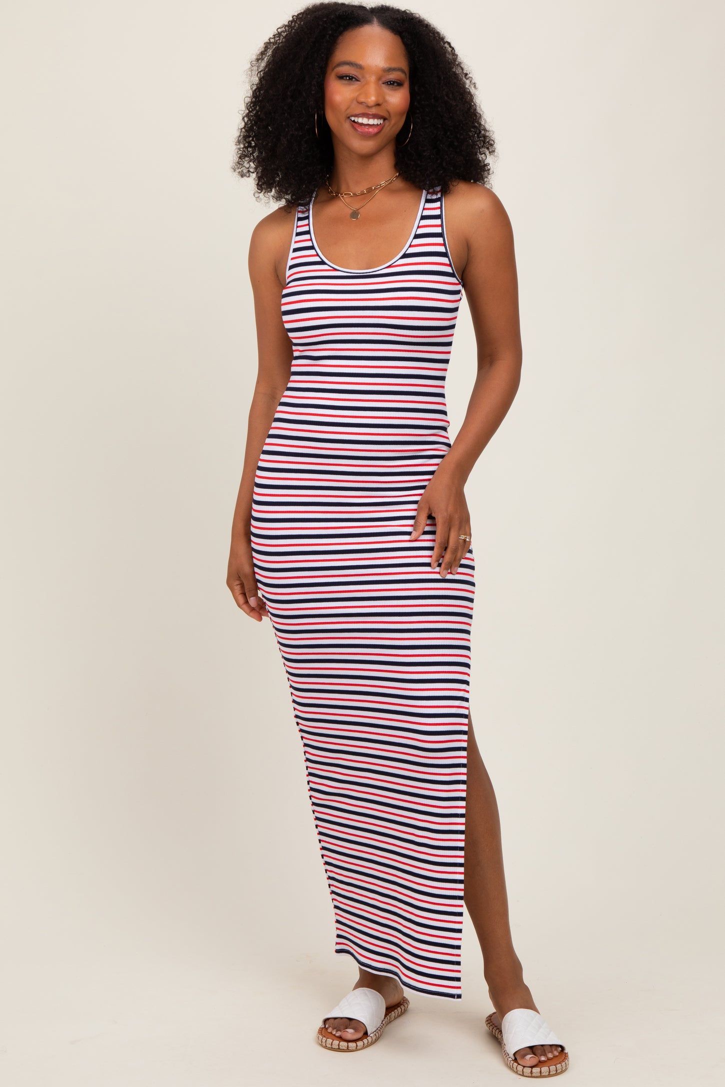 woman wearing a navy and white striped maxi dress with a side slit and smiling at the camera