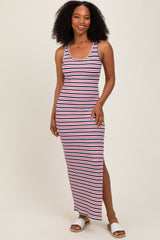 woman wearing a navy and white striped maxi dress with a side slit and smiling at the camera